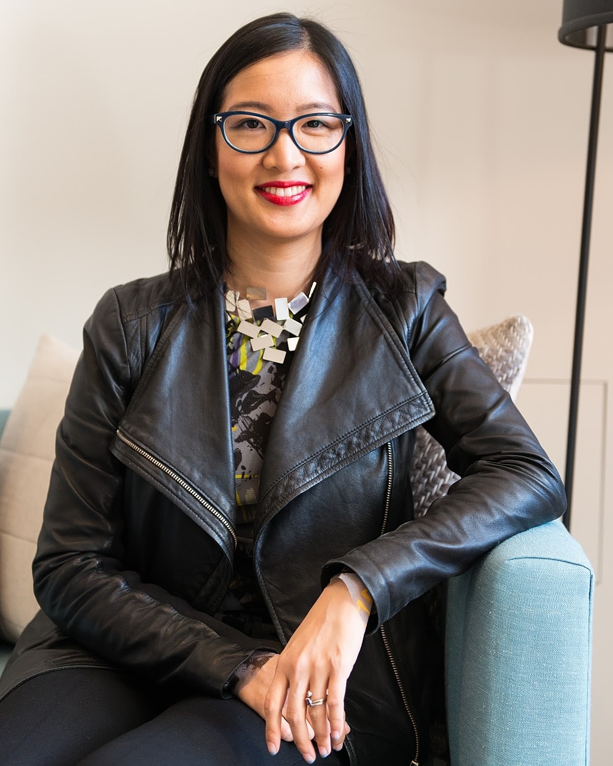 Woman in black jacket sitting on a couch.