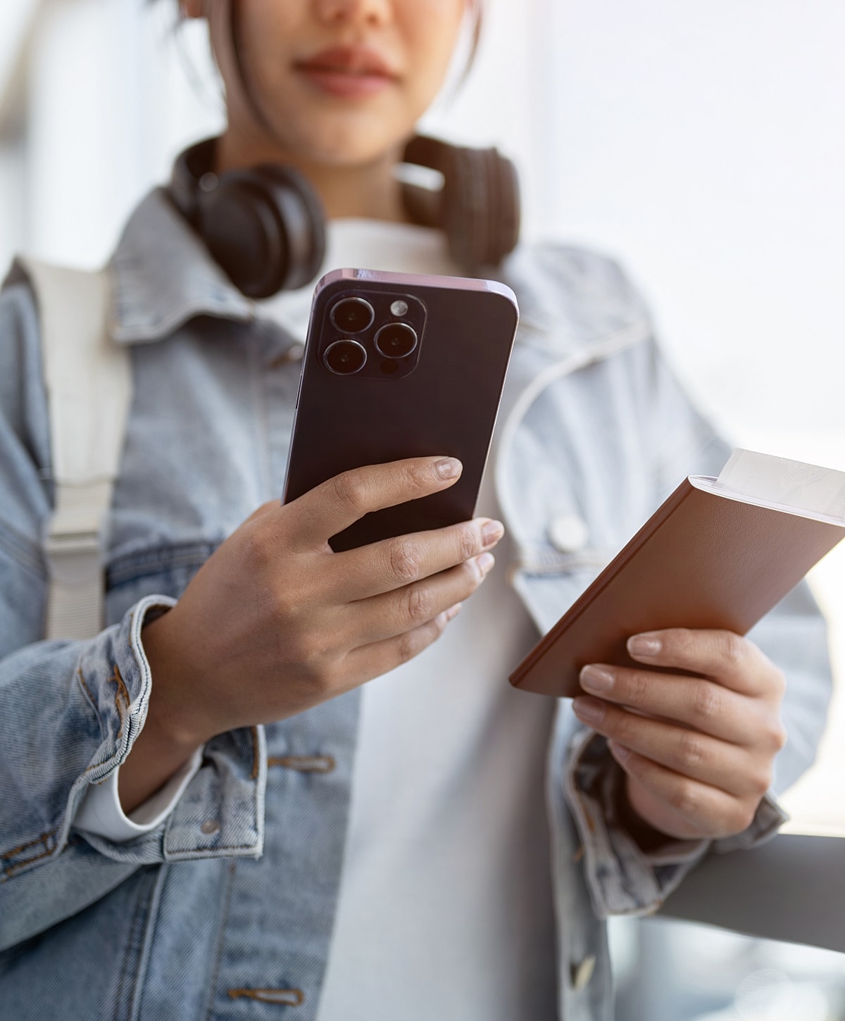 Person holding phone and passport, traveling concept.
