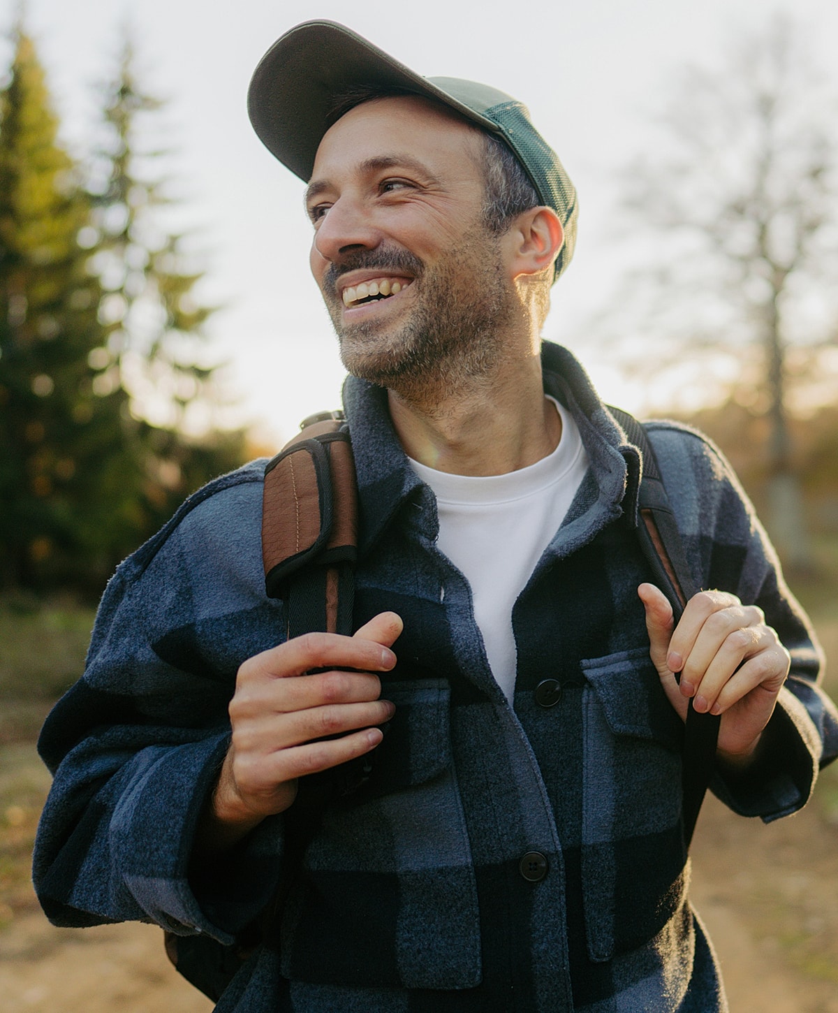Smiling man in outdoor setting with backpack.