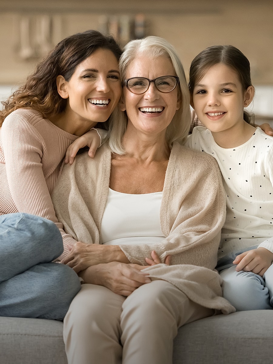 Three generations of women smiling together.