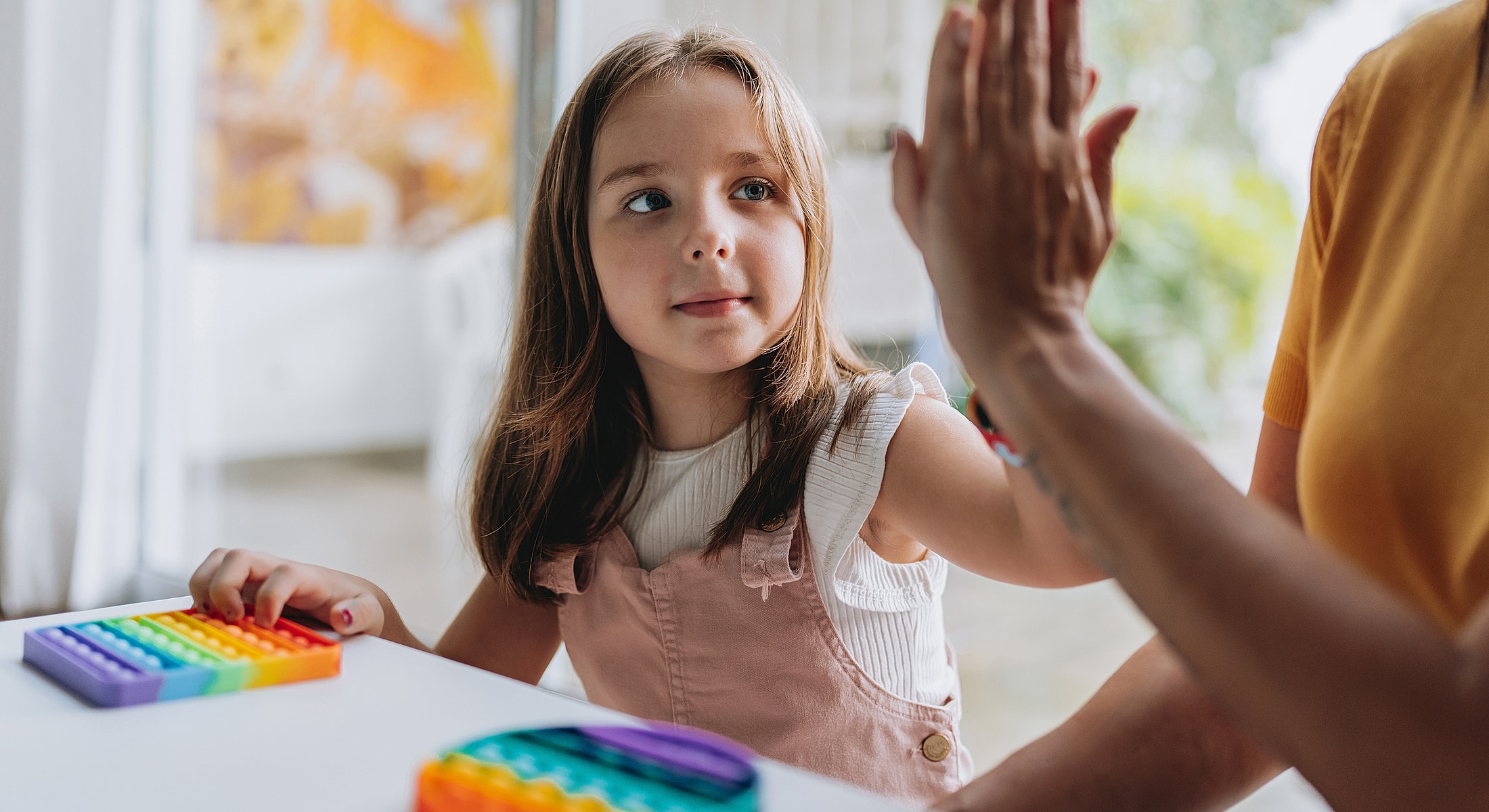 Child playing with colorful sensory toys indoors.