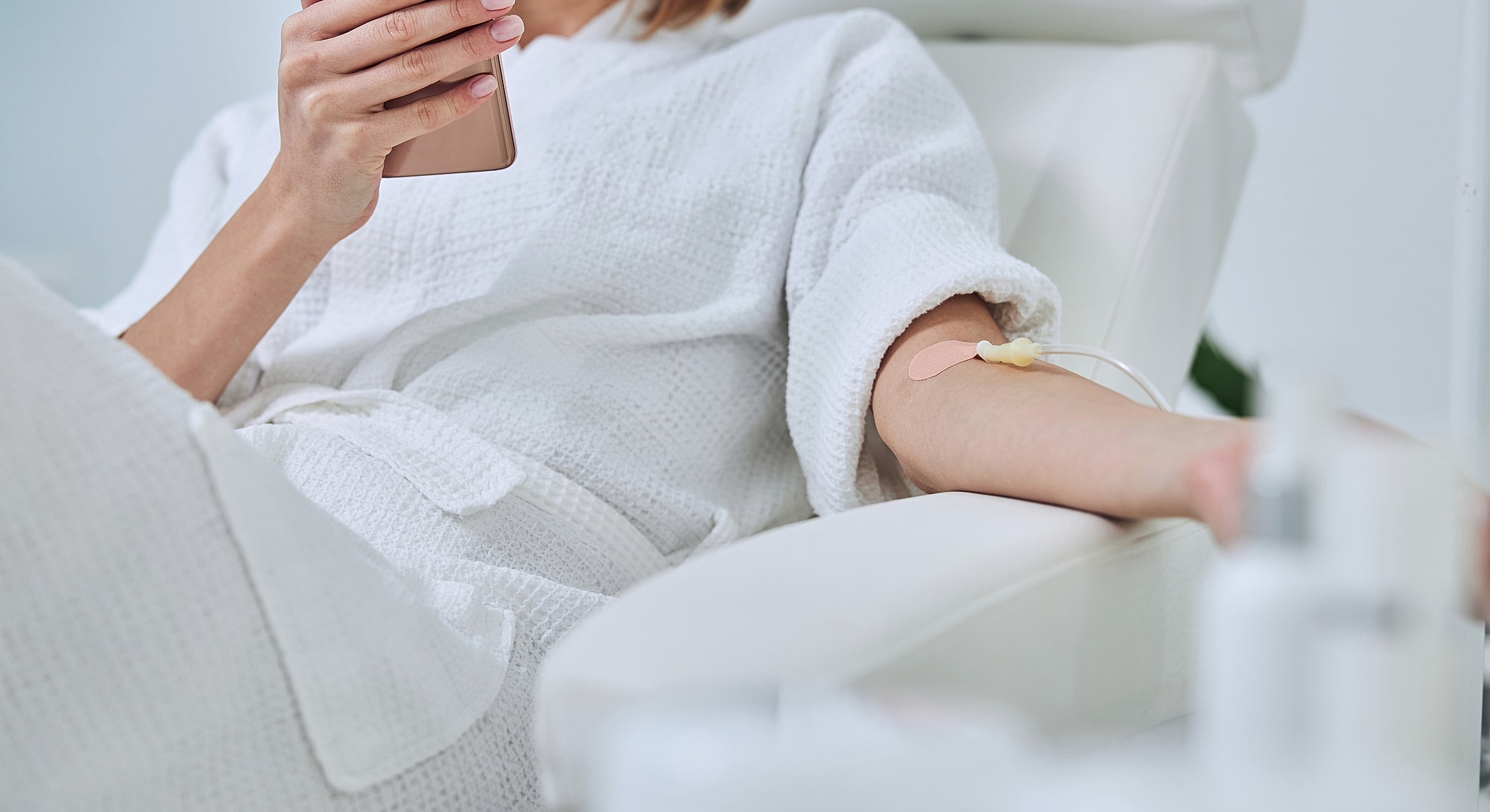 Person receiving treatment while using smartphone.